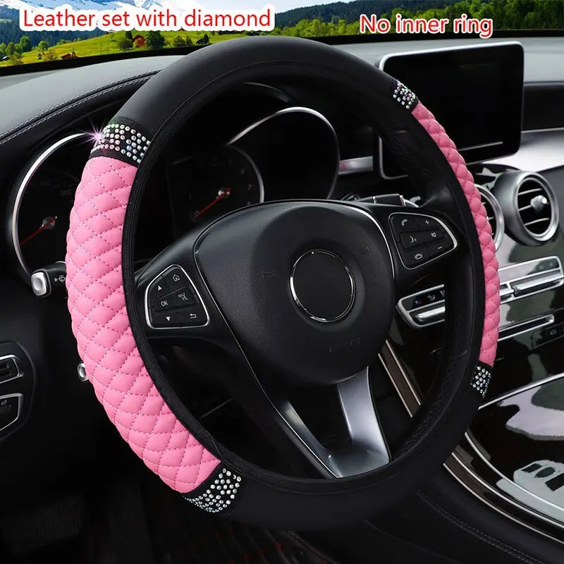 Pink faux leather steering wheel cover with diamond accents installed in a car interior.