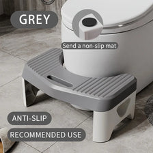 A grey comfort squatting stool with an anti-slip tray is shown next to a toilet.