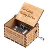 A wooden music box with a lid engraved 'Can't Help Falling In Love' and a hand crank mechanism.