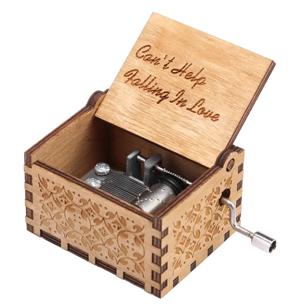A wooden music box with a lid engraved 'Can't Help Falling In Love' and a hand crank mechanism.