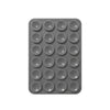 A gray silicone suction pad with multiple circular indentations for phone mounts.