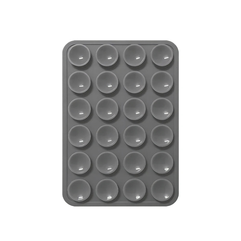 A gray silicone suction pad with multiple circular indentations for phone mounts.