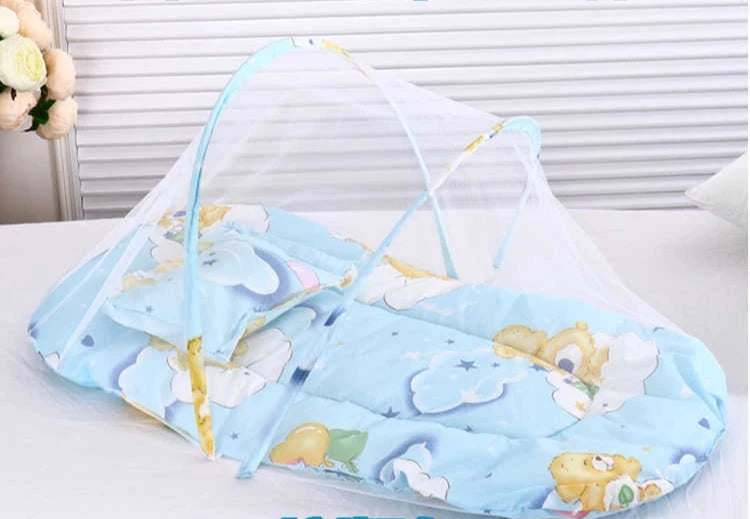 A light blue foldable baby mosquito net is shown spread out with a mattress and pillow on a white surface.