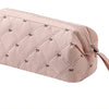 A light pink quilted storage bag for a portable hair dryer and styling tool with a fabric strap.
