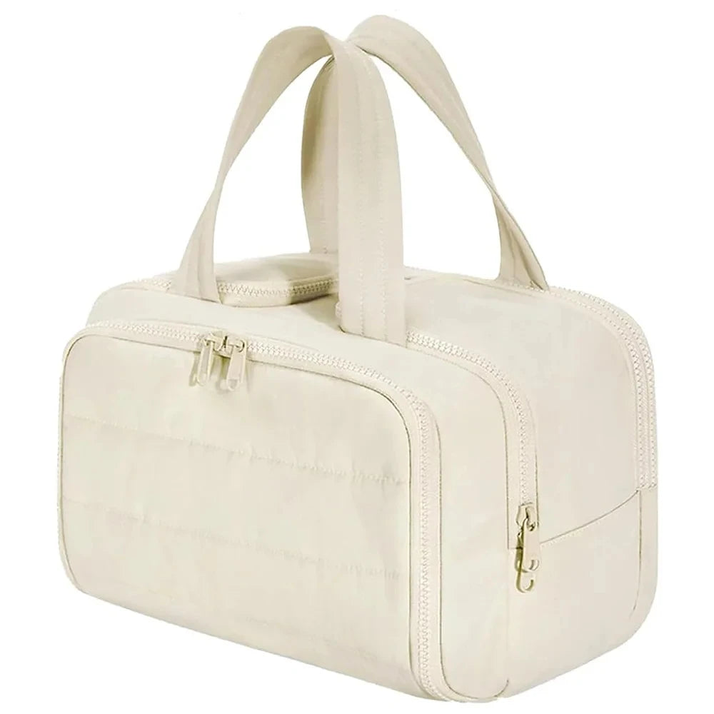 A cream-colored travel makeup bag with a wide opening and carrying straps.
