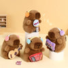Three brown capybara plush toys with various accessories sitting on a light surface.