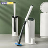 A white disposable toilet cleaning brush with a black handle and storage base is shown on a gray surface.