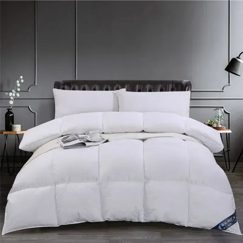 A luxury white goose and duck down comforter with a cotton cover displayed on a bed.