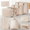 A set of beige travel packing cubes and storage organizer bags displayed on a light gray surface.