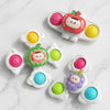 A collection of colorful baby suction cup spinner toys featuring various fruit shapes and sensory beads.