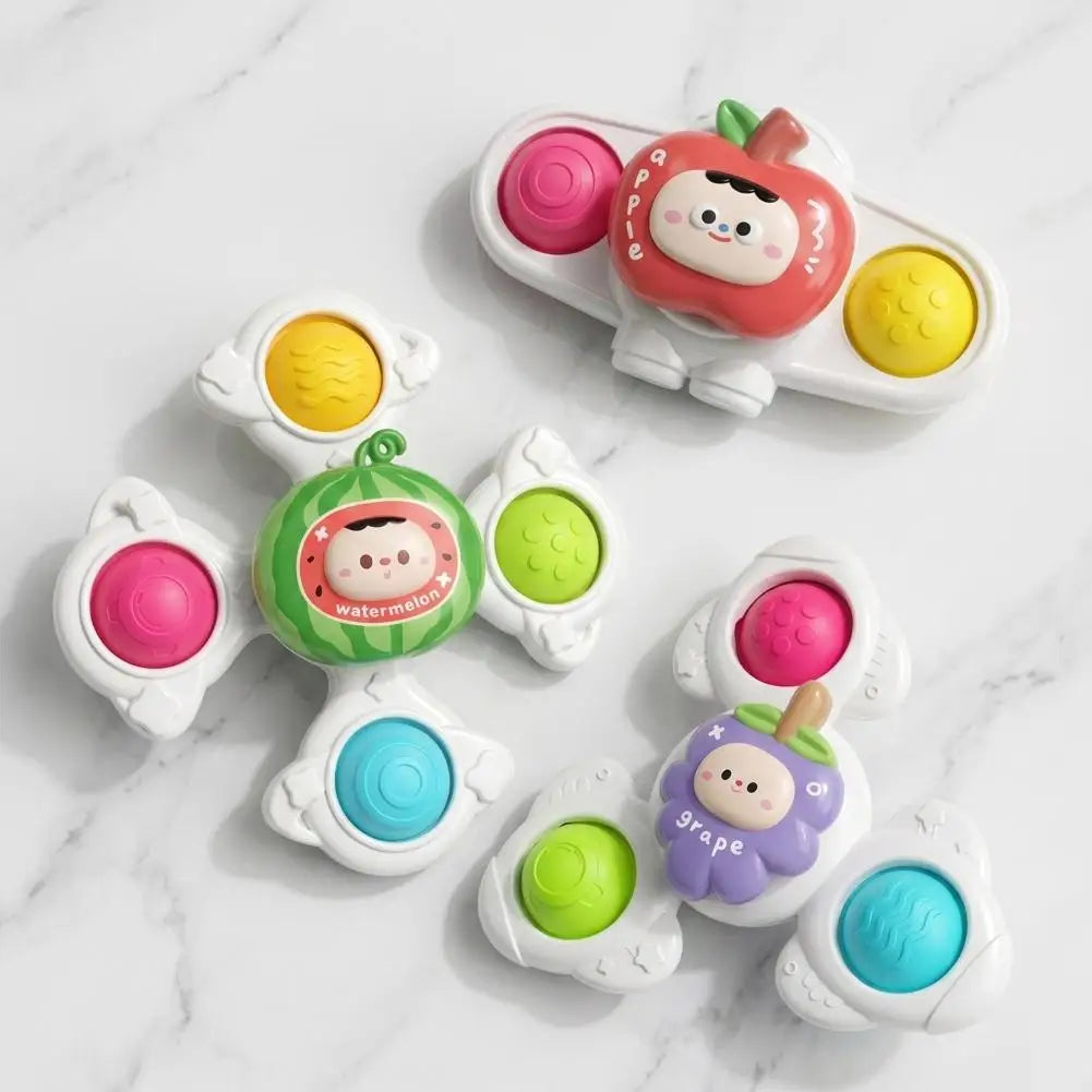 A collection of colorful baby suction cup spinner toys featuring various fruit shapes and sensory beads.