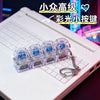 A set of clear LED macaron keyboard fidget toys are displayed on a white laptop keyboard.