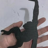 A hand holds a black wooden monkey-shaped wall hook for keys and decor.