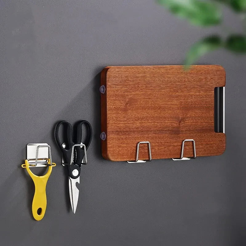 A wooden block holder with a stainless steel sponge and kitchen tool organizer featuring suction cups.