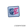 A blue embroidered patch featuring a stylized fish design and the text Shake That Bass in pink thread.