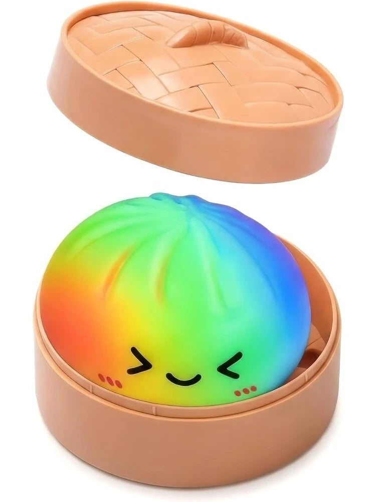 A pink silicone squishy toy shaped like a dumpling with a rainbow gradient color effect inside a matching lid.