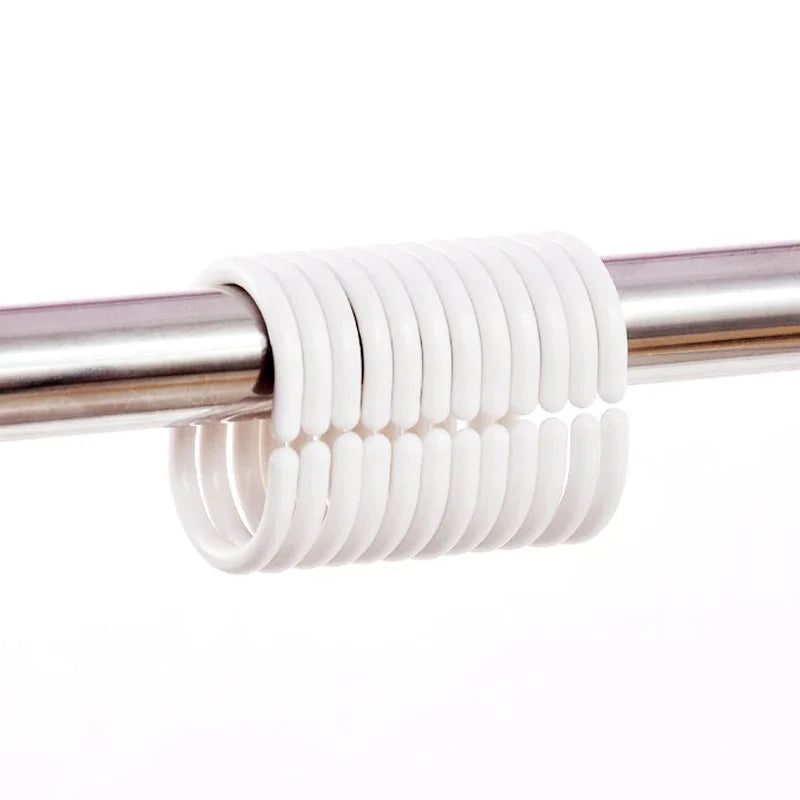 White silicone shower curtain rings coiled on a metal rod for bathroom decor