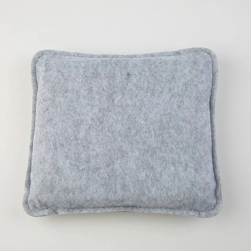 A square, gray needle felting mat made of wool for crafting.