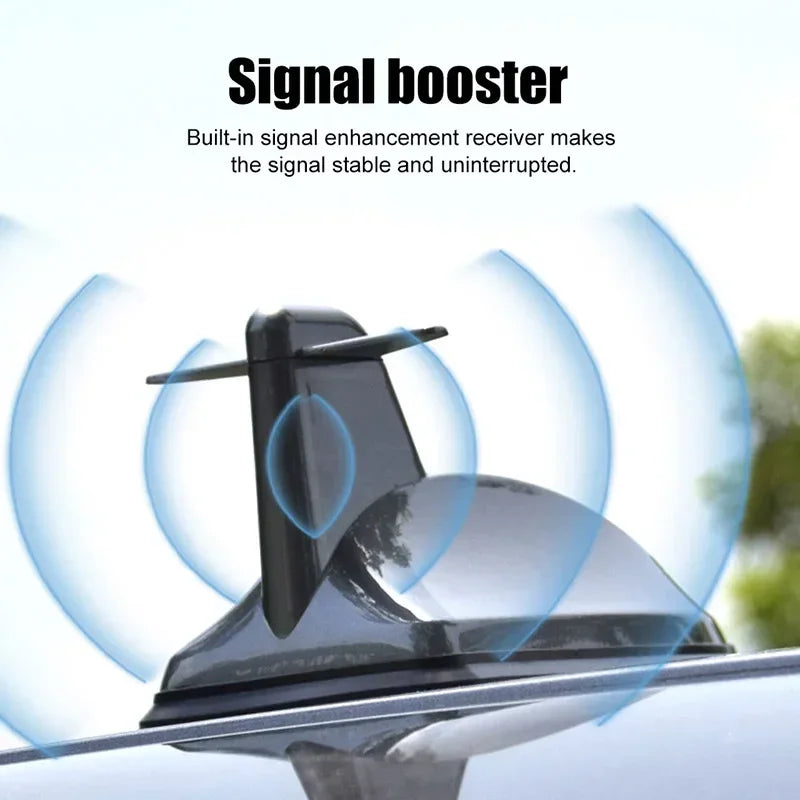 A close-up of a Shark Fin car antenna signal booster device mounted on a vehicle's roof.