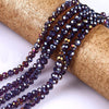 Purple faceted crystal glass spacer beads threaded onto a golden ribbon roll