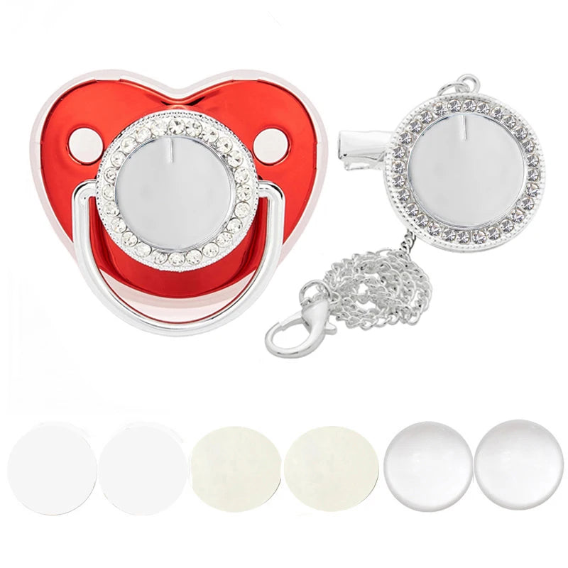 A sparkling rhinestone pacifier with a clip designed for babies, featuring a heart-shaped red and silver design.