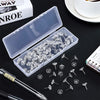 A transparent plastic box filled with clear thumb tacks and push pins is shown on a dark surface.