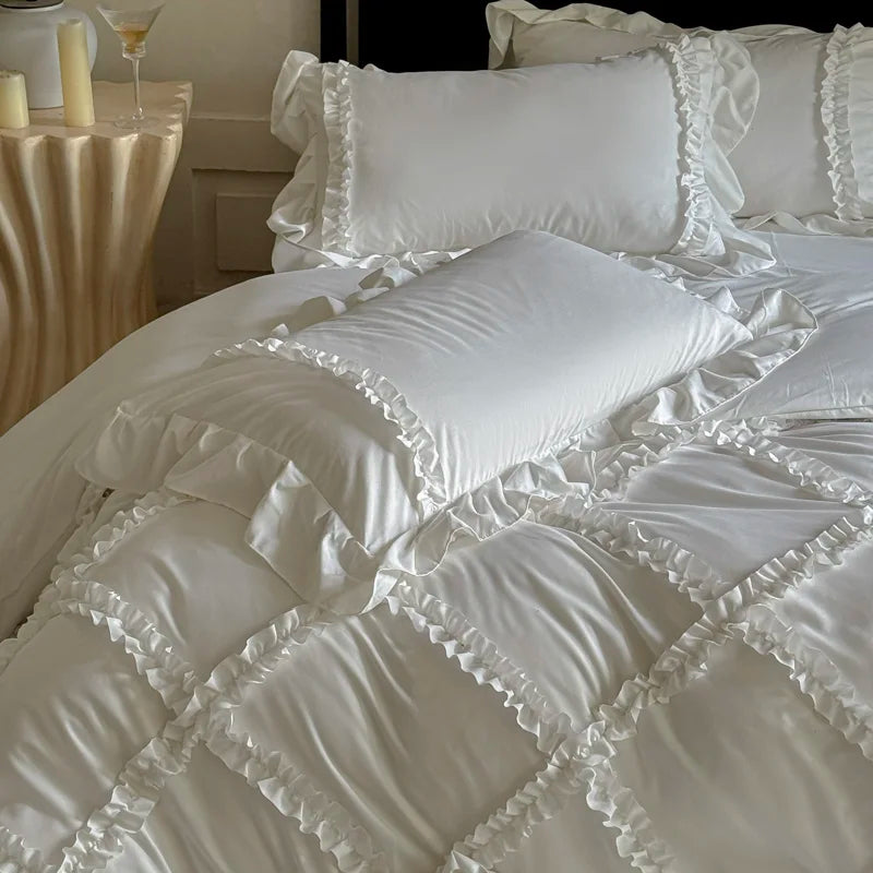 White ruffled duvet cover set with matching pillowcases and a decorative bed display.