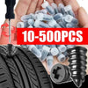 A hand holds a pile of self-repair rubber tire puncture nails and a black tire tread.