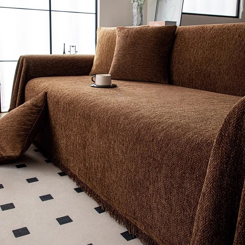 A dark brown herringbone chenille sofa throw draped over a sofa with matching accent pillows.