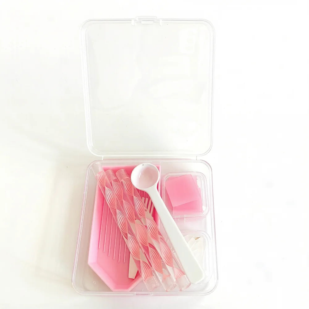 A clear storage box containing a complete diamond painting accessory kit with pink tools and tools.