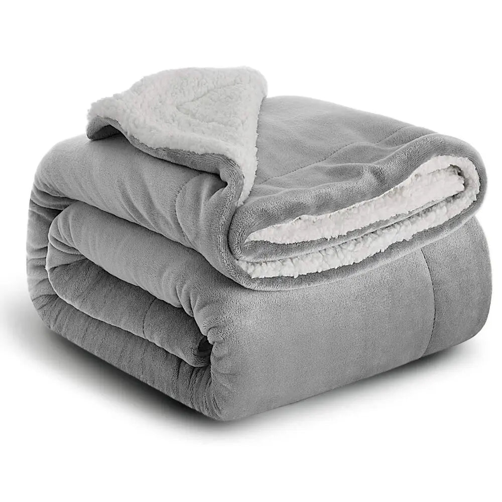 Manta de sherpa gris extra gruesa enrollada y doblada.