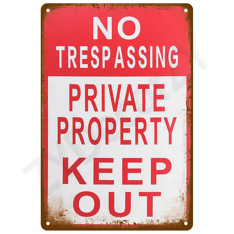 A vintage red and white metal tin sign with the text NO TRESPASSING PRIVATE PROPERTY KEEP OUT.