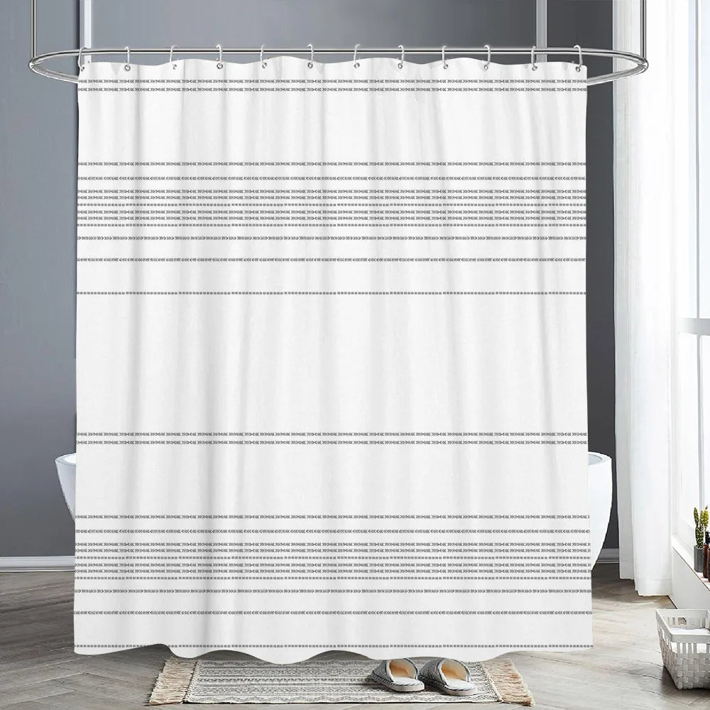 White shower curtain with a black and white geometric pattern hanging from a metal rod in a bathroom setting.