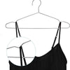 A black camisole top hanging on a stainless steel wire clothes hanger.