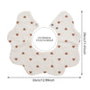 A light beige muslin cotton baby bib or burp cloth with a scalloped edge and small brown hearts printed on it.