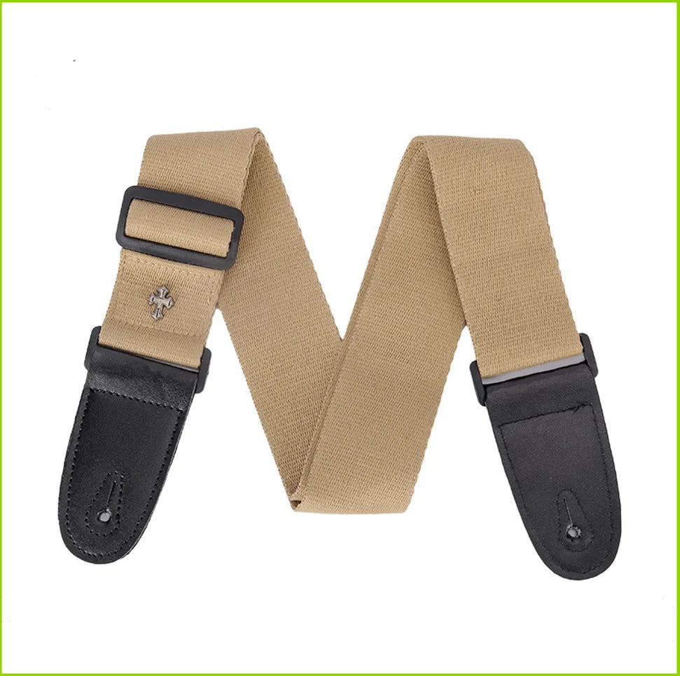 Tan guitar strap with a black pick pocket and vintage cross pattern detail