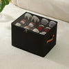 A black foldable shoe organizer with a dustproof lid is shown resting on a white textured surface.