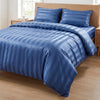 A blue satin striped jacquard duvet cover set displayed on a wooden bed with matching pillows.