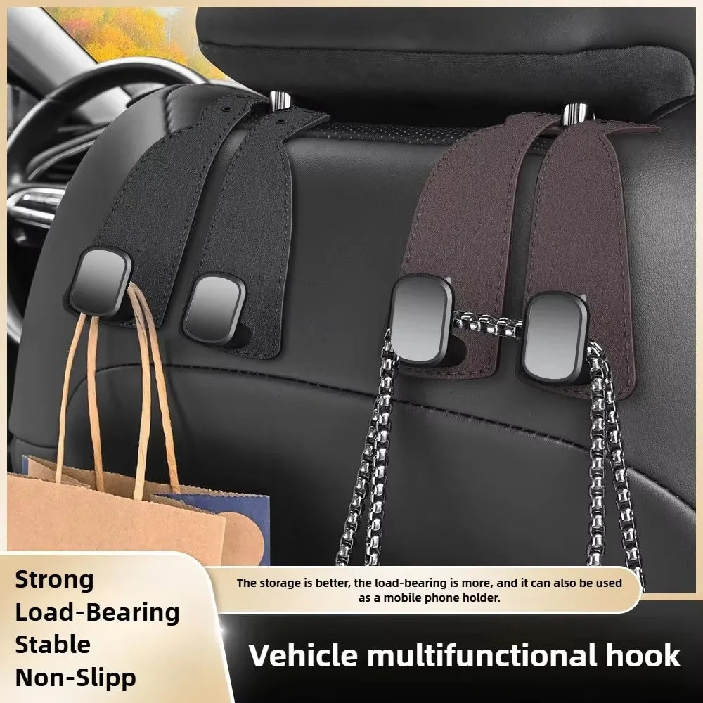 A close-up of a black car seat back showing dual brown suede hooks used for hanging bags and other items.