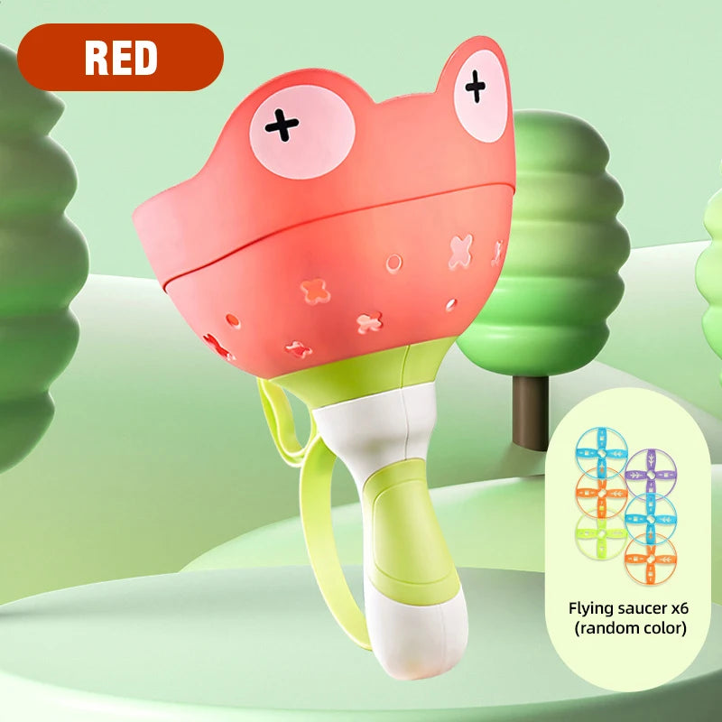 A red pull-string flying saucer toy frog with a green base and various colored plastic shapes.