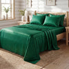 A dark emerald green striped satin bed sheet set with matching pillows on a wooden bed.