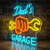 Blue and orange neon sign shaped like a fist with the words Dad's Garage glowing on a brick wall.