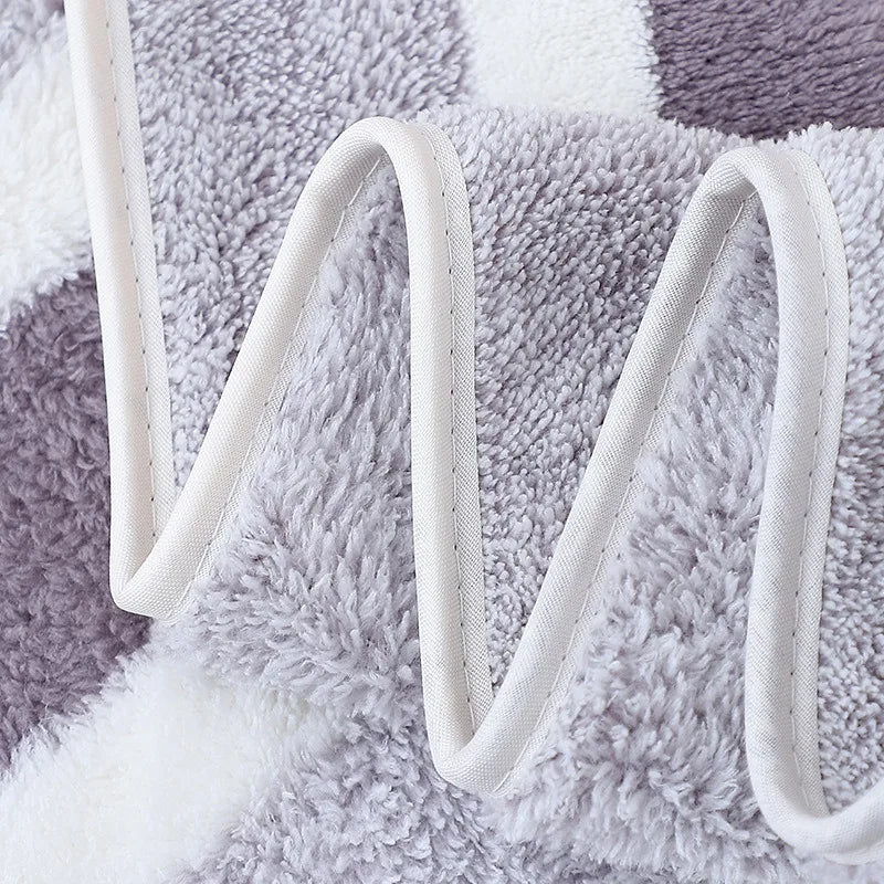 A close-up of a gray and white microfiber bath towel set with white straps.