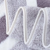 A close-up of a gray and white microfiber bath towel set with white straps.