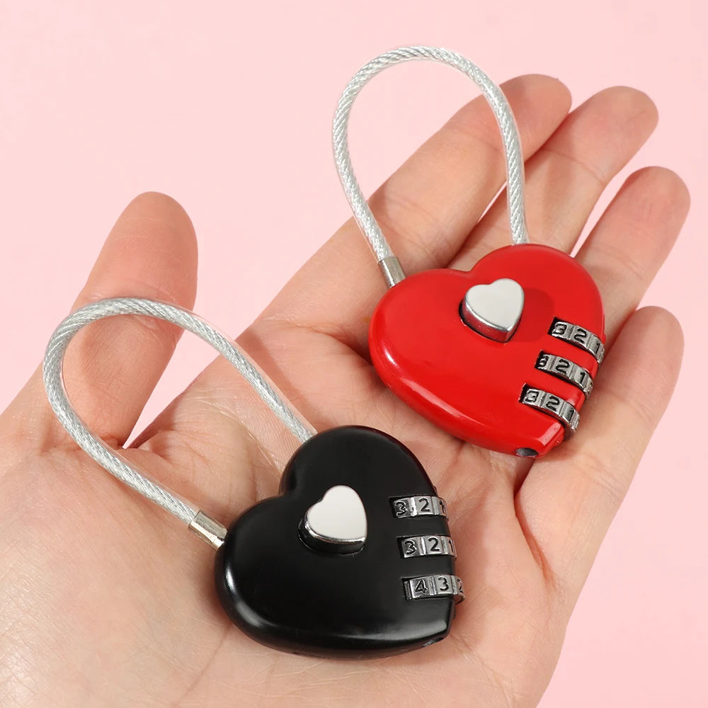 A hand holds a red heart-shaped padlock and a black heart-shaped padlock, both featuring a three-digit combination lock.