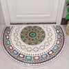 A semi-circle doormat featuring a colorful, intricate tribal boho pattern with geometric designs in blues, yellows, and earth