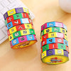 A stack of colorful Montessori math cubes showing numbers and arithmetic operations on a wooden surface.