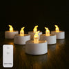 Flameless LED tea light candles glowing on a dark wooden surface with a remote control nearby