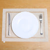 A white dinner plate, knife, and fork are placed on a natural linen placemat on a wooden table.