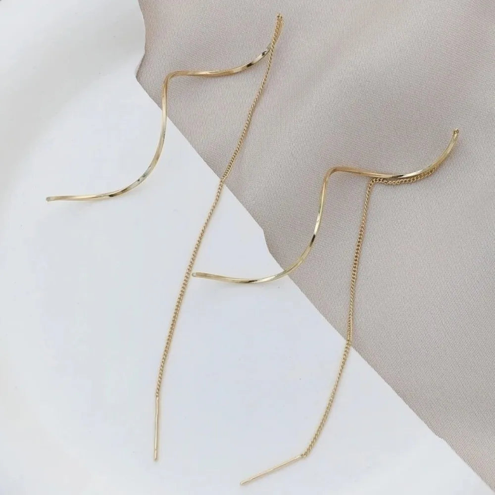 Gold long chain threader earrings displayed on a neutral background.